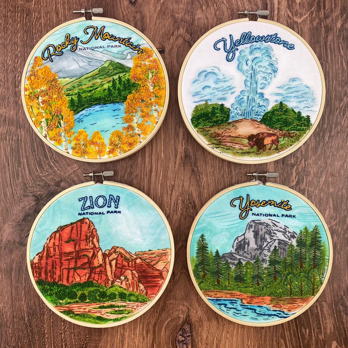 Collection of 4 embroidery designs of national parks. Zion, Yosemite, Yellowstone and Rocky  Mountain National Parks on a brown wood background